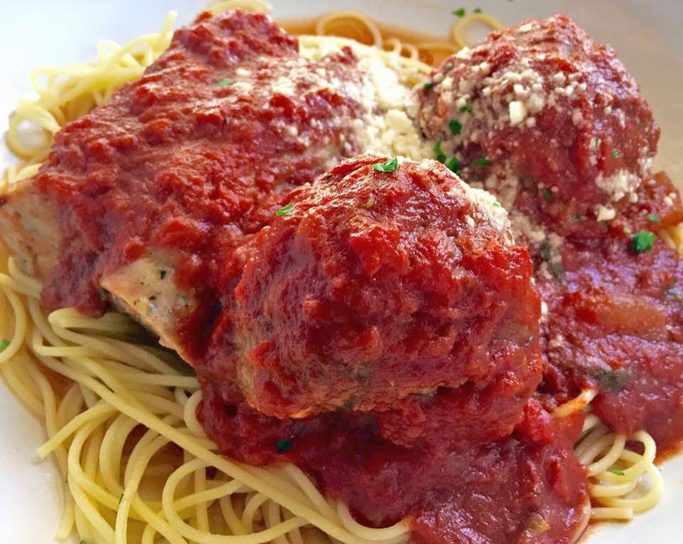 Two large meatballs in red sauce over spaghetti