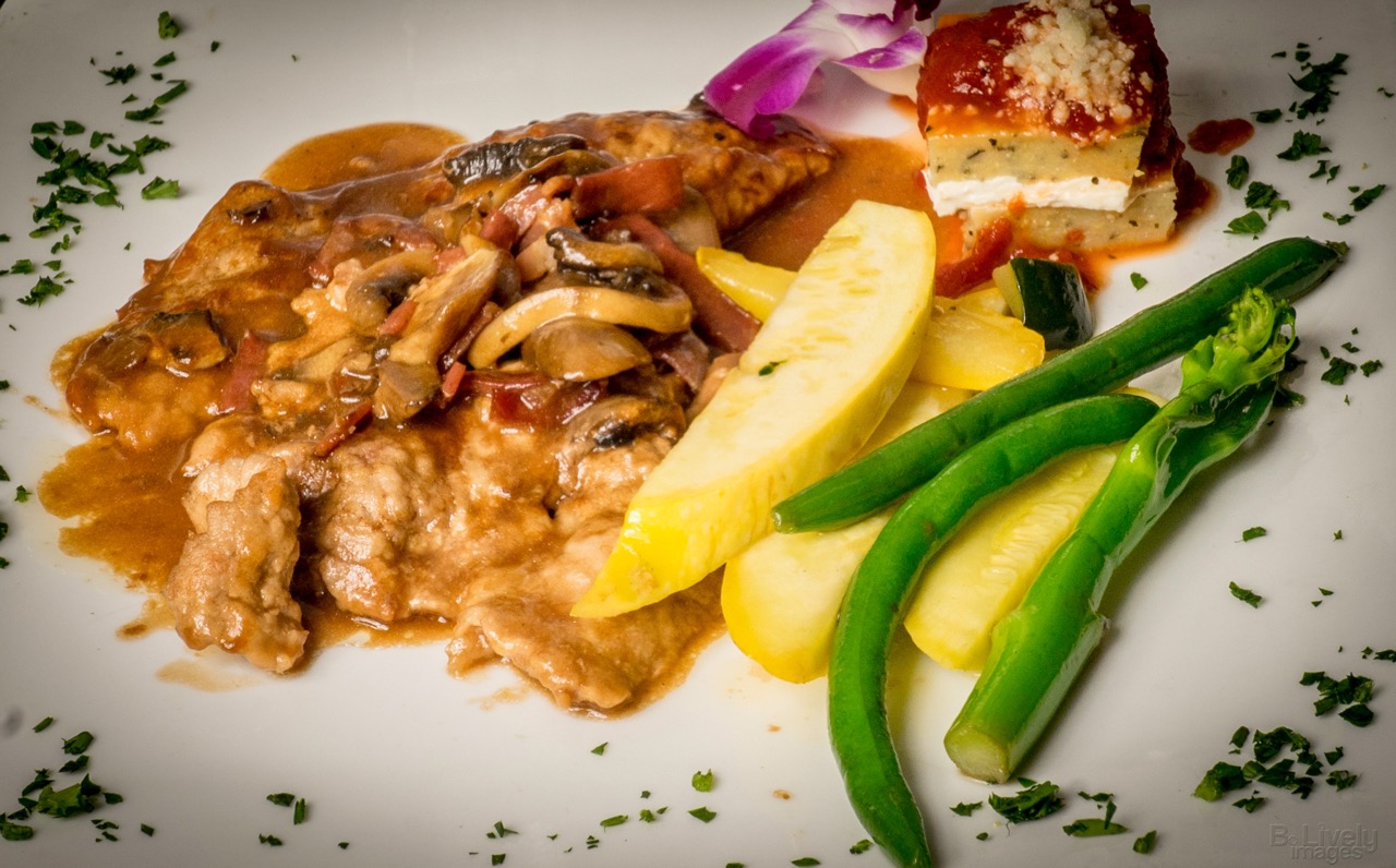 Veal marsala with mushrooms beside yellow squash, green beans and a slice of lasagna